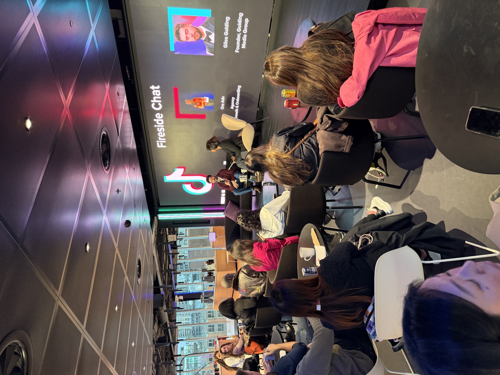 Wide view of the packed audience at TikTok HQ Fireside Chat with London skyline visible through windows