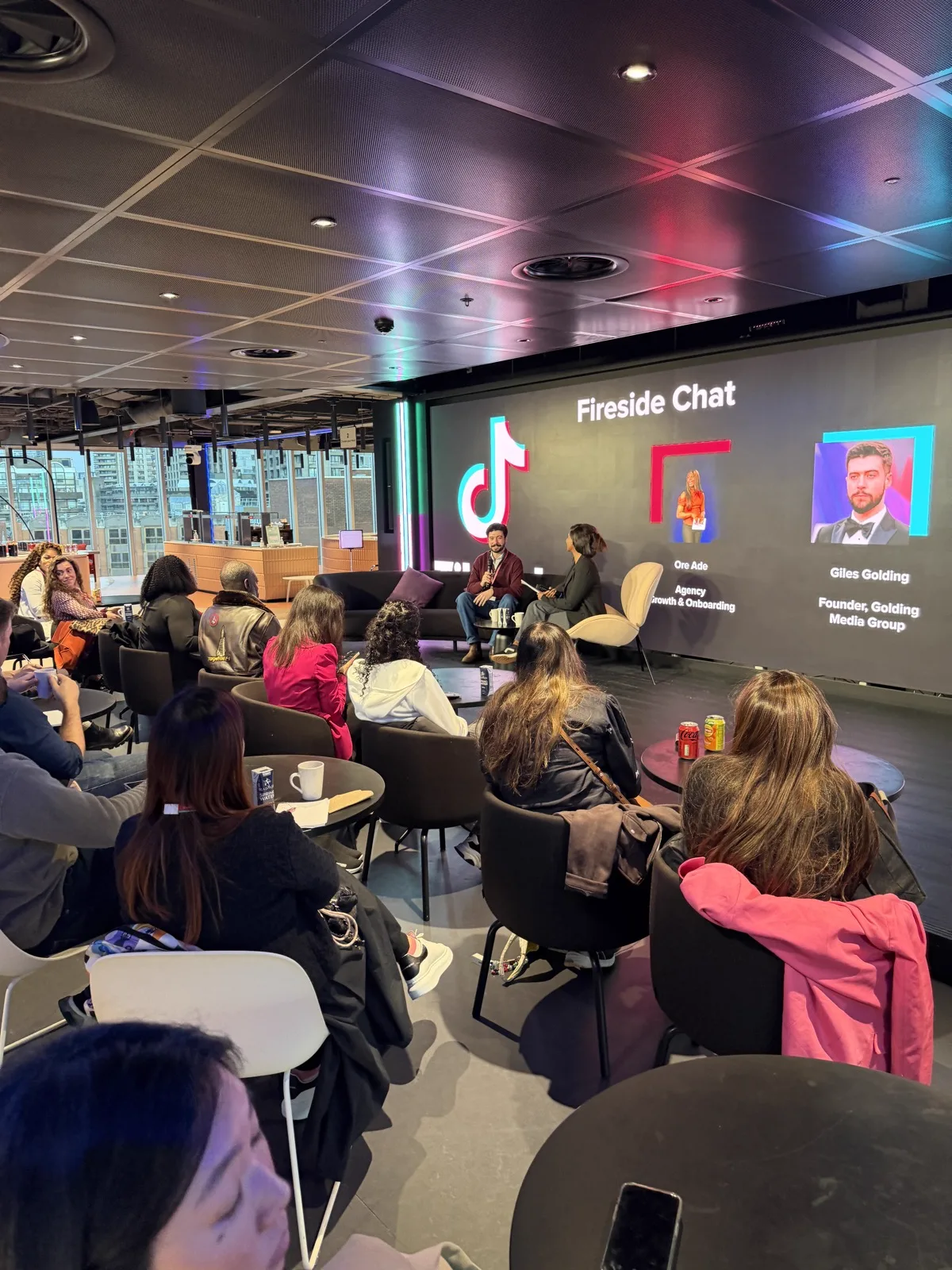 Wide view of the packed audience at TikTok HQ Fireside Chat with London skyline visible through windows
