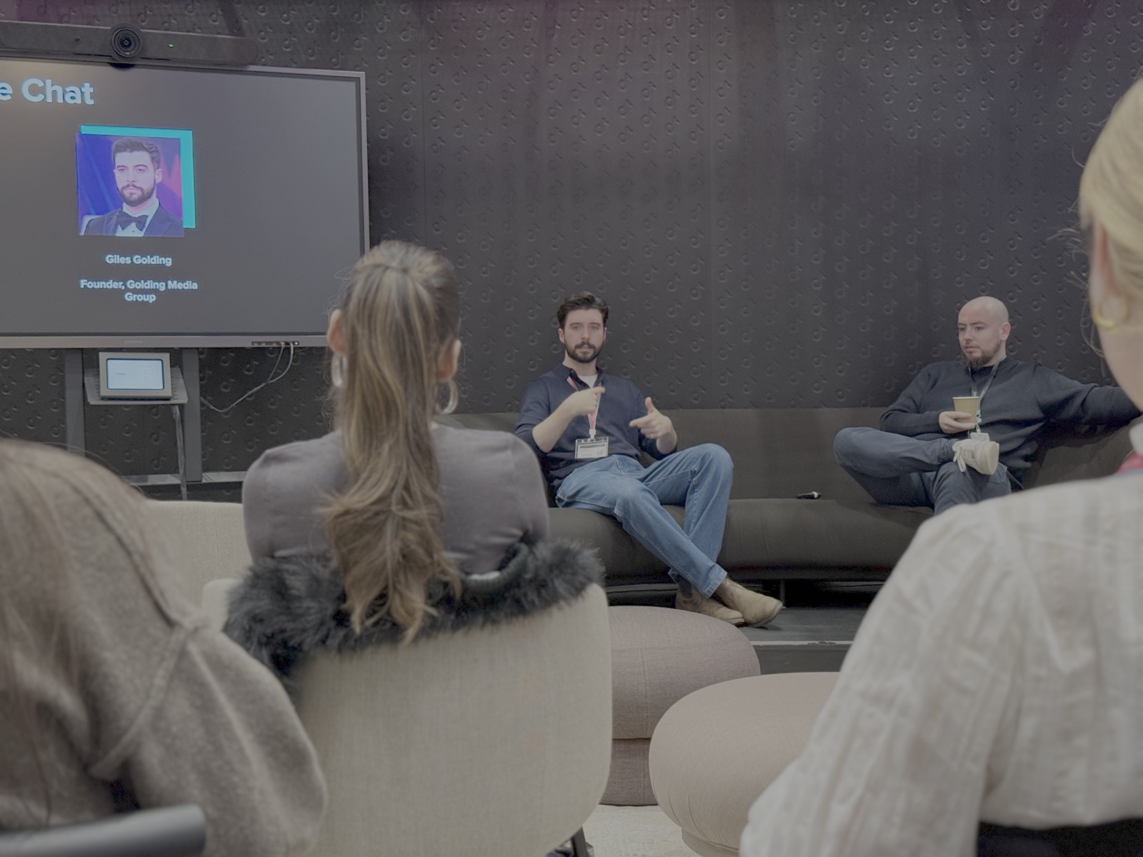 Close-up of Giles Golding speaking at TikTok's Fireside Chat with presentation slide showing Founder, Golding Media Group